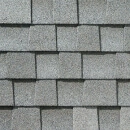 Close-up view of overlapping gray asphalt roof shingles arranged in a staggered pattern, showing their rough texture and slight color variations.