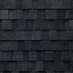 Close-up view of dark gray asphalt roof shingles arranged in a repetitive, staggered pattern, creating a textured, overlapping surface.