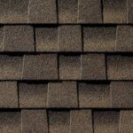 Close-up view of brown asphalt roof shingles arranged in an overlapping pattern, showing their rough, textured surface.