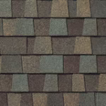 Close-up of overlapping asphalt roof shingles in various shades of brown and gray, creating a textured, patterned surface.