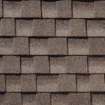 Close-up view of brown asphalt roof shingles arranged in a uniform, overlapping pattern.