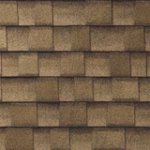 Close-up of overlapping brown roof shingles arranged in a horizontal pattern, showing the texture and color variation of the roofing material.
