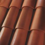 Close-up view of overlapping reddish-brown clay roof tiles arranged in neat rows, creating a textured and uniform pattern.