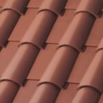 Close-up view of a red clay tiled roof, showing overlapping curved tiles arranged in neat, parallel rows.
