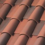 Close-up of overlapping reddish-brown ceramic roof tiles arranged in a repeating pattern, creating a textured surface commonly seen on traditional rooftops.