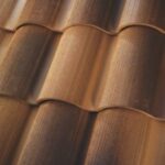 Close-up view of brown, curved ceramic roof tiles arranged in overlapping rows, showing texture and shading.