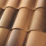 Close-up view of brown ceramic roof tiles arranged in overlapping rows, showing their smooth, curved surfaces and uniform pattern.