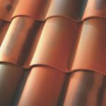 Close-up view of red-brown ceramic roof tiles, arranged in overlapping rows with a curved, wavy design.