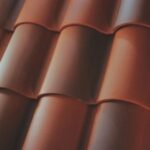 Close-up view of reddish-brown, curved ceramic roof tiles arranged in a repeating pattern, showing smooth texture and natural lighting.