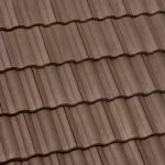Close-up view of brown, wavy ceramic roof tiles arranged in neat, horizontal rows. The tiles have a textured surface and appear uniform and well-constructed.