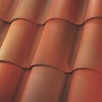 Close-up of overlapping red clay roof tiles arranged in neat, horizontal rows, creating a wavy pattern with shadows and highlights.