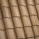 Close-up view of overlapping, brown ceramic roof tiles arranged in neat, horizontal rows, creating a textured and uniform pattern.