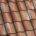 Close-up view of overlapping reddish-brown clay roof tiles, showing a repeating pattern and variations in color and texture.