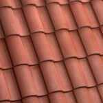 Close-up view of overlapping red clay roof tiles arranged in neat, parallel rows, creating a textured and uniform pattern.
