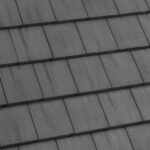 A close-up view of a gray tiled roof, showing overlapping rectangular tiles arranged in neat, horizontal rows.