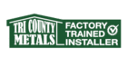 Green and white logo with a house-shaped outline reading "Tri County Metals" on the left and "Factory Trained Installer" with a check mark inside a gear on the right.